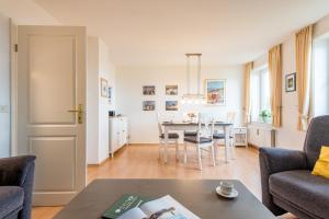 een woonkamer met een tafel en stoelen bij Haus Decker, App 3 in Wenningstedt +20 foto's