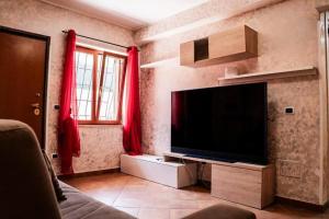 een woonkamer met een flatscreen-tv aan de muur bij Cristian Case Vacanza in Colonna