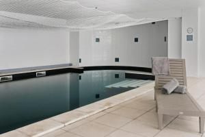 een zwembad met een stoel naast een zwembad bij T2 moderne avec piscine, terrasse et parking privé in Uzès