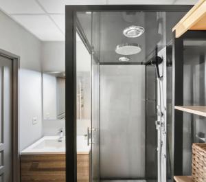 een glazen douchedeur in een badkamer met een wastafel bij T2 moderne avec piscine, terrasse et parking privé in Uzès +25 foto's