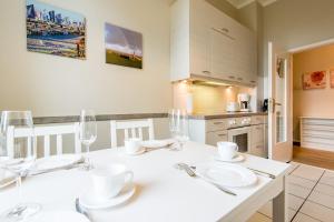 a kitchen with a table with white plates and wine glasses at Haus Decker, App 2 in Wenningstedt