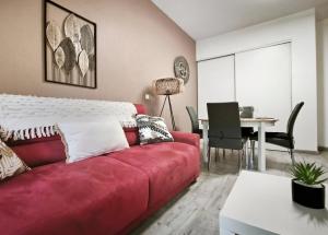 een woonkamer met een rode bank en een tafel bij T2 moderne avec piscine, terrasse et parking privé in Uzès