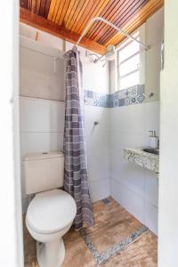 een badkamer met toilet en douchegordijn bij Studio Romântico in Volta Redonda