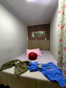 een kamer met een bed waarop een rode helm ligt bij Studio Romântico in Volta Redonda