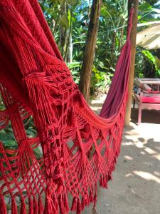 a red hammock is hanging in a garden at Pousada Magia da Mata in Trindade