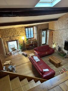 een woonkamer met een rode bank en een tafel bij La genivriere in Bugarach