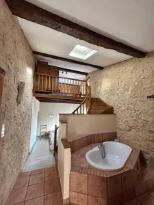 een badkamer met een bad en een trap bij La genivriere in Bugarach