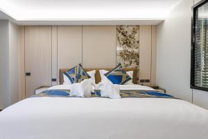 a bedroom with a large bed with blue and white pillows at Marquis Hotel in Ban Bang Toei (1)