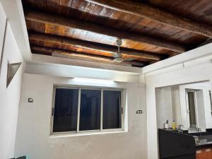 a room with a wooden ceiling and a window at Meridian penthouse in Kolhapur