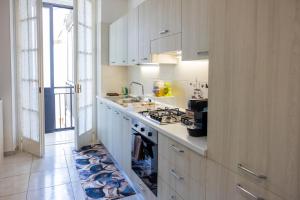 a kitchen with white cabinets and a stove top oven at Cairoly Residence in Termoli
