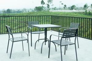 een tafel en stoelen op een terras met een hek bij Zalfa Hills  +2 foto's