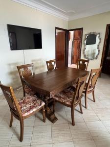 a wooden dining room table with chairs and a tv at Entire Ocean-View Apartment in Rabat