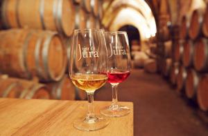 two wine glasses sitting on a table in a wine cellar at Gite Le Tamaris in Mantry