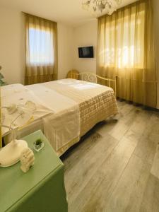 ein Schlafzimmer mit einem Bett und einem Tisch und einem Fernseher in der Unterkunft B&B Il Grande Cipresso in Castelnuovo