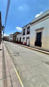 an empty street with buildings on the side of the road at Casona Bartolome in Morelia