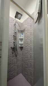 a tiled bathroom with a soap dispenser on the wall at Casa Lu Salentu - Monolocale superior in Torre Lapillo +35 photos