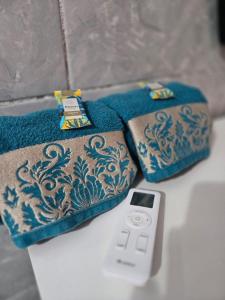 two towels and a cell phone on a table at Quarto familia "até 4 pessoas" próximo ao aeroporto e rodoviaria in São Luís