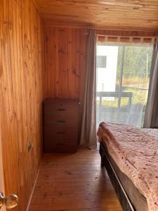 een slaapkamer met een bed en een groot raam bij Cabañas Vitalis in Curanipe +5 foto's