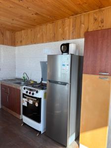 een keuken met een fornuis en een roestvrijstalen koelkast bij Cabañas Vitalis in Curanipe