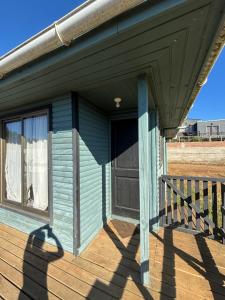 een veranda van een blauw huis met een raam bij Cabañas Vitalis in Curanipe