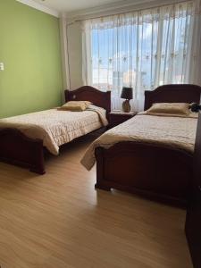 een slaapkamer met 2 bedden en een raam met uitzicht bij Apartamento Cómodo cerca del centro in Loja