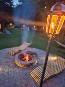 een vuurplaats op een stenen terras naast een straatlantaarn bij Los horneros in General Rodríguez