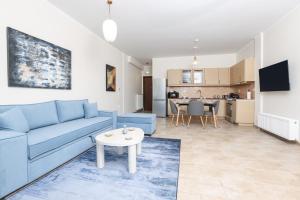 a living room with a blue couch and a table at Smart Home Corfu 4 in Alykes Potamou