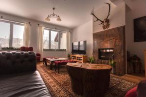 a living room with a couch and a table at Dwór i Dworek Leszczowate Wellness & Spa in Ustrzyki Dolne
