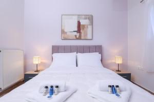 a bedroom with a large white bed with two lamps at Smart Home Corfu 4 in Alykes Potamou