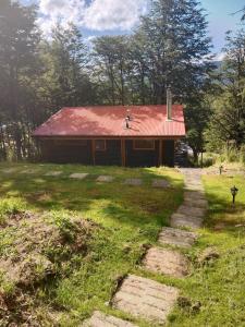 een huis met een rood dak en een pad dat er naar toe leidt bij Cabañita con o sin Tinaja Ruta657 in Coihaique +16 foto's