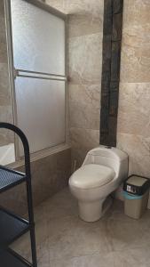 een badkamer met een wit toilet en een vuilnisbak bij Apartamento Cómodo cerca del centro in Loja