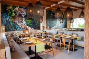 a restaurant with tables and chairs and a mural at Hotel NYX Cancun in Cancún