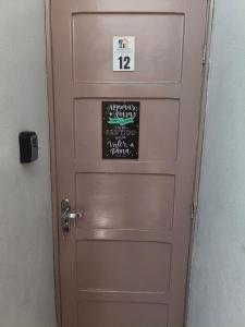 une porte rose avec un tableau noir dessus dans l'établissement Chalé Diamante c /AR, à Volta Redonda