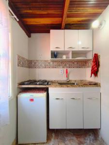 une cuisine avec des armoires blanches et un évier dans l'établissement Chalé Diamante c /AR, à Volta Redonda