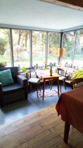 un salon avec une table, des chaises et des fenêtres dans l'établissement La Sirène Endormie, à Penmarcʼh