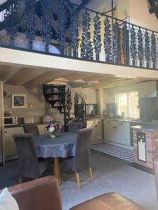 une cuisine et une salle à manger avec une table et des chaises dans l'établissement The Barn, à Stourbridge