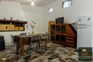 een keuken met een tafel, stoelen en een koelkast bij Casa El Chaparral Villa Dolores, Traslasierra 3 in Piedra Pintada