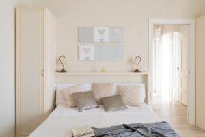 a white bedroom with a white bed with pillows at Mondial Beauty Suite in Bellaria-Igea Marina +6 photos