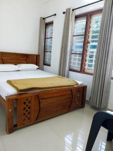 een slaapkamer met een groot houten bed voor een raam bij Nature's View Service Villa in Vythiri