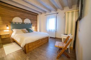 a bedroom with a large bed and a wooden wall at Le Vigne Incantate in Santa Maria di Feletto