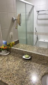 ein Badezimmer mit Waschbecken und Glasdusche in der Unterkunft Tropical Executive in Manaus + 1 Foto