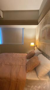 ein Schlafzimmer mit einem Bett mit Kissen und einer Lampe in der Unterkunft Tropical Executive in Manaus