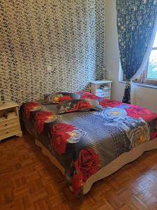 een slaapkamer met een bed met rode bloemen erop bij Karachalios Maisonette in Karyes