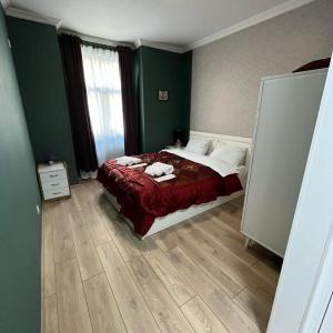 een slaapkamer met een bed met een rode sprei bij Mika's Apartment in Tbilisi City