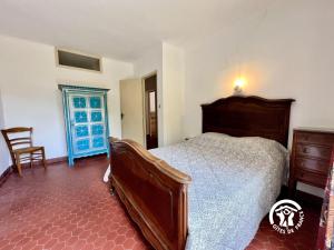 een slaapkamer met een bed en een stoel bij L angele in Portel-des-Corbières