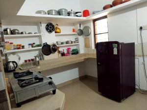 a kitchen with a stove and a refrigerator at Nature's View Service Villa in Vythiri
