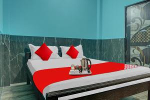 ein Bett mit roten Kissen und einem Mixer darauf in der Unterkunft Hotel O B K Brothers in Gulzārbāgh
