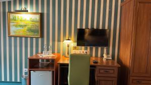 a room with a desk with a computer and a television at Pensjonat Cezar in Siemiatycze