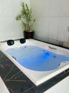 eine Badewanne mit blauem Wasser im Bad in der Unterkunft Chalé cipreste 3 Quartos in Gramado
