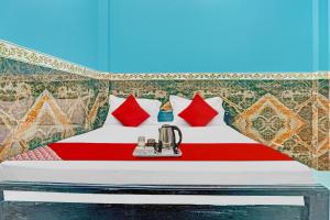 ein Schlafzimmer mit einem Bett mit roten Kissen in der Unterkunft Hotel O B K Brothers in Gulzārbāgh + 17 Fotos